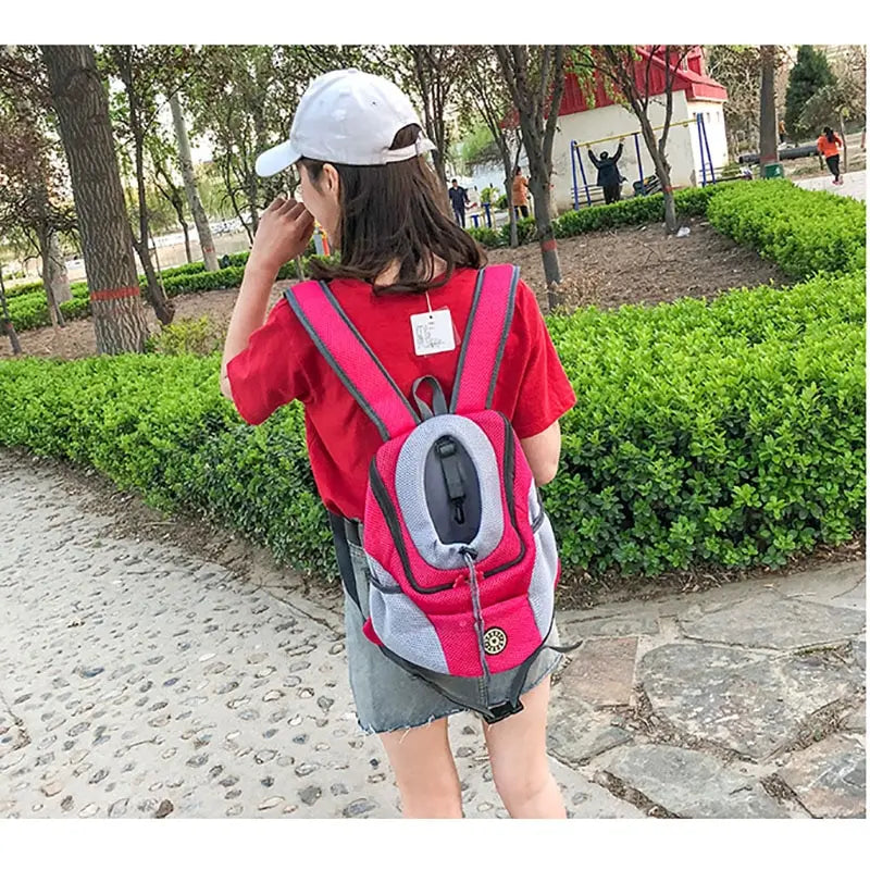 Person wearing a Portable Pet Backpack Carrier in a park setting, showcasing comfort and functionality for pet travel.